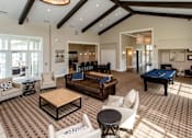 Thumbnail 8 of 15 - a large living room with a pool table and couches at The Winhall of Williams Pointe Apartments, Waukee, IA, 50263
