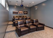 Thumbnail 9 of 15 - a large media room with leather couches and chairs at The Winhall of Williams Pointe Apartments, IOWA, 50263