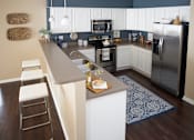 Thumbnail 1 of 15 - a kitchen with stainless steel appliances and a long counter top at The Winhall of Williams Pointe Apartments, Waukee