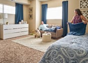 Thumbnail 11 of 15 - a man and a woman in a bedroom with a dog at The Winhall of Williams Pointe Apartments, IOWA