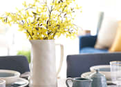 Thumbnail 14 of 15 - a table with a vase with yellow flowers on it at The Winhall of Williams Pointe Apartments, Waukee, IA