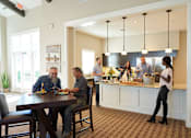 Thumbnail 4 of 15 - a group of people sitting around a table in a kitchen at The Winhall of Williams Pointe Apartments, Waukee, 50263
