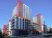 Thumbnail 2 of 13 - a group of tall buildings with orange balconies on a city street