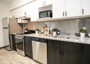 Thumbnail 7 of 13 - a kitchen with stainless steel appliances and a granite counter top