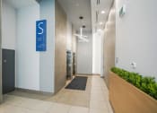 Thumbnail 3 of 13 - a hallway of elevators in a building with a blue sign on the wall