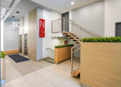 Thumbnail 5 of 13 - the lobby of a building with a staircase and a reception desk