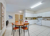Thumbnail 21 of 33 - A kitchen with a table and chairs in the middle of the room.