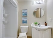Thumbnail 27 of 33 - A white bathroom with a toilet, sink, and mirror.