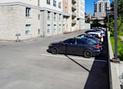 Thumbnail 6 of 17 - A parking lot with a car parked in the middle.