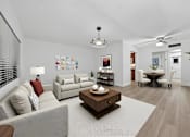 Thumbnail 2 of 21 - A living room with a grey couch, a coffee table, and a dining table with chairs.