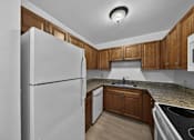 Thumbnail 19 of 21 - A kitchen with a white refrigerator and wooden cabinets.