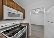 Thumbnail 17 of 21 - A kitchen with a white oven, microwave, and refrigerator.