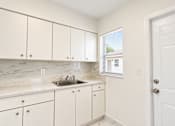 Thumbnail 19 of 19 - A kitchen with white cabinets and a marble countertop.