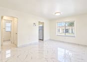 Thumbnail 12 of 19 - A spacious room with marble flooring and a window overlooking a building.