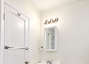 Thumbnail 18 of 19 - A white bathroom with a toilet, sink and medicine cabinet.