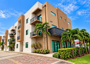 Thumbnail 6 of 48 - A modern building with balconies and green doors.