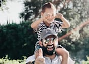 Thumbnail 14 of 15 - a man holding a child on his shoulders and giving a thumbs up