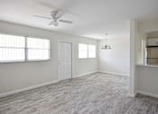 Thumbnail 8 of 15 - an empty living room with a ceiling fan and a window
