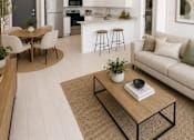 Thumbnail 1 of 25 - A modern living room with a kitchen in the background.