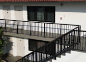 Thumbnail 16 of 21 - A black metal railing on a staircase.