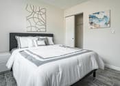 Thumbnail 4 of 15 - A bedroom with a large bed and a painting on the wall.