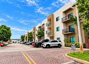 Thumbnail 1 of 48 - A white building with a black car in front of it.