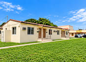 Thumbnail 2 of 19 - A house with a green lawn in front of it.