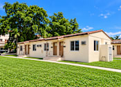 Thumbnail 1 of 19 - A row of houses with green lawns in front.