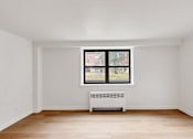 Thumbnail 21 of 49 - A room with a window and a radiator on the floor.