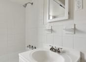 Thumbnail 28 of 49 - A white sink in a bathroom with a mirror above it.