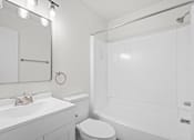 Thumbnail 8 of 16 - A white bathroom with a toilet, sink, and shower.