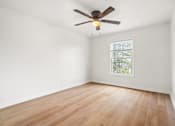 Thumbnail 16 of 31 - A room with a ceiling fan and a window.