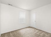 Thumbnail 20 of 29 - A room with a carpeted floor, a window with blinds, and a door.