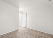 Thumbnail 22 of 29 - A white room with a carpeted floor and a door.