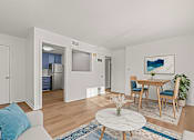 Thumbnail 2 of 28 - A living room with a white couch and a round marble coffee table.