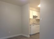 Thumbnail 10 of 38 - A kitchen with white appliances and wooden floors.
