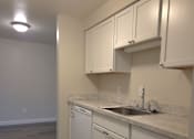 Thumbnail 9 of 38 - A kitchen with white cabinets and a marble countertop.