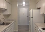 Thumbnail 11 of 38 - A kitchen with white cabinets and a white fridge.