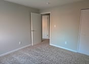 Thumbnail 13 of 38 - A room with a carpeted floor and a doorway leading to another room.