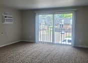 Thumbnail 9 of 17 - A room with a carpet floor and a window with blinds.