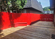 Thumbnail 15 of 17 - A red fence surrounds a wooden deck.