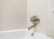 Thumbnail 21 of 28 - A white bathtub with a chrome faucet and shower head.