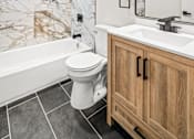 Thumbnail 15 of 31 - A white toilet sits in a marble bathroom.