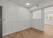 Thumbnail 11 of 28 - A room with white walls and wooden flooring.
