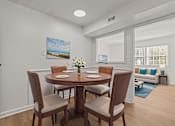 Thumbnail 4 of 28 - A dining room with a table set for two and a painting on the wall.