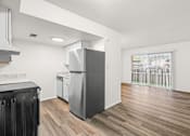 Thumbnail 9 of 29 - A kitchen with a black cabinet and a grey fridge.