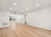 Thumbnail 12 of 31 - A room with wooden flooring and white walls.
