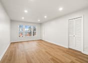 Thumbnail 9 of 31 - A room with wooden floors and white walls.
