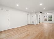 Thumbnail 19 of 31 - A room with wooden floors and white walls.