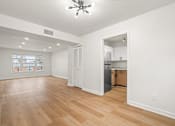 Thumbnail 11 of 31 - A spacious room with wooden floors and a ceiling fan.